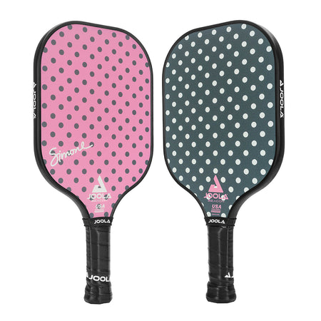 White background, product image of a set of JOOLA Beacon Pickleball Paddles. The paddle on the left is pink with polkadots and the paddle on the right is green with polkadots.