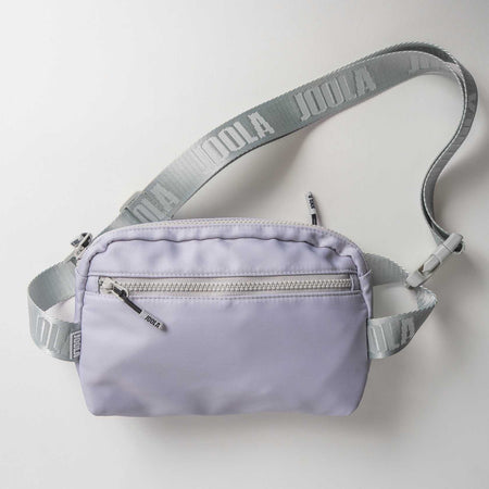 Gray background, product image of a JOOLA Belt Bag, purple with a gray handle.