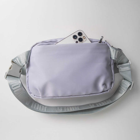 Gray background, image of a purple JOOLA Belt Bag with a cellphone peaking out of the front pocket.