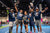 Group of people celebrating on a pickleball court with rackets