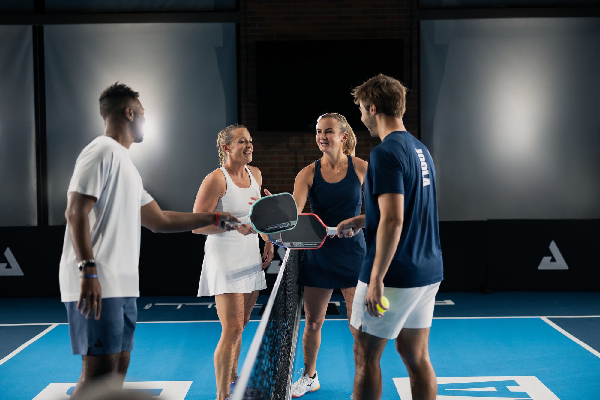 Donald Young, Brooke Buckner, Kate Fahey and Ben Johns all doing a paddle tap at the net.