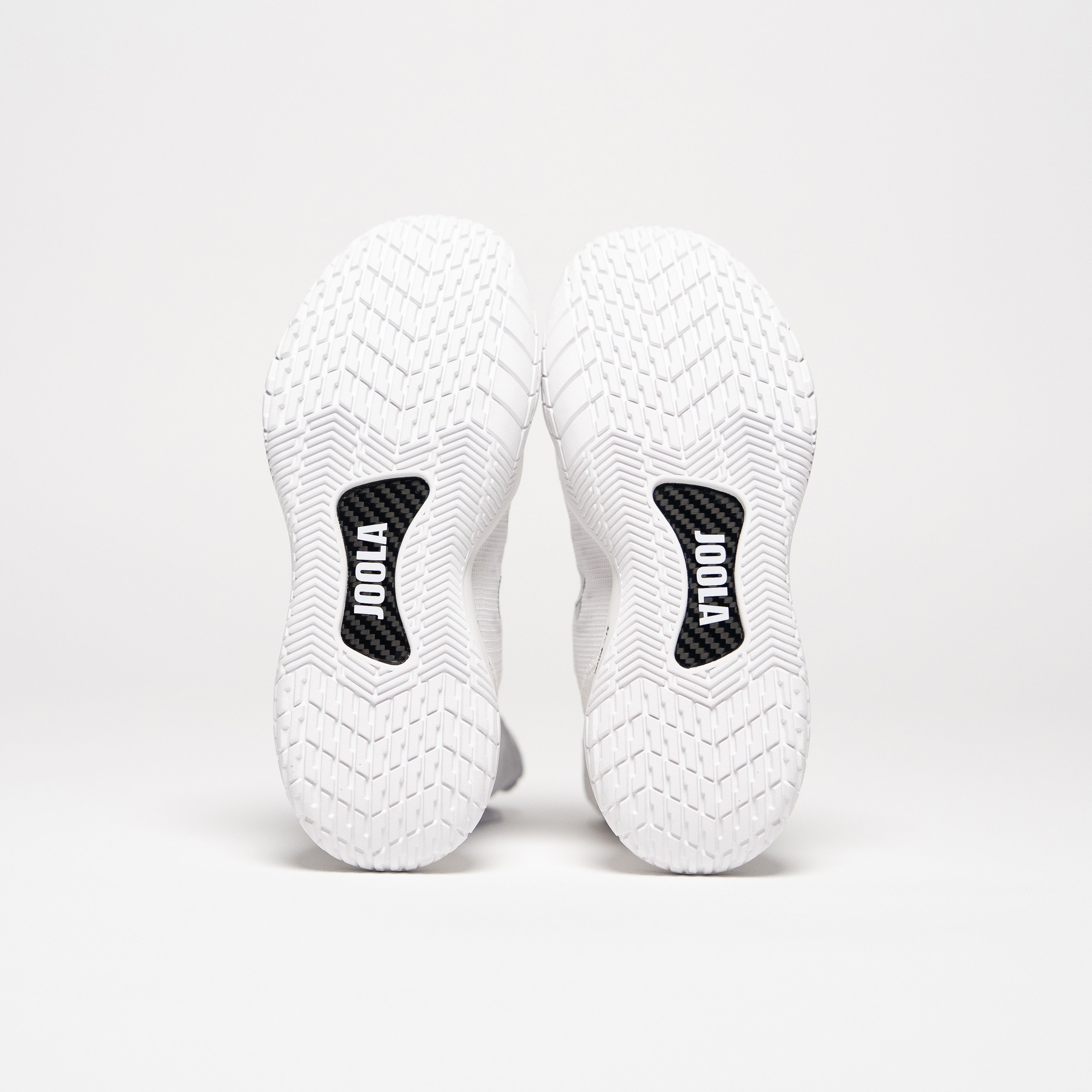 Image showing the bottom of a pair of JOOLA R4LLy pickleball shoes, the way the shoes are posed it's showing the JOOLA Branded Carbon Fiber Shank in the sole of the shoe.