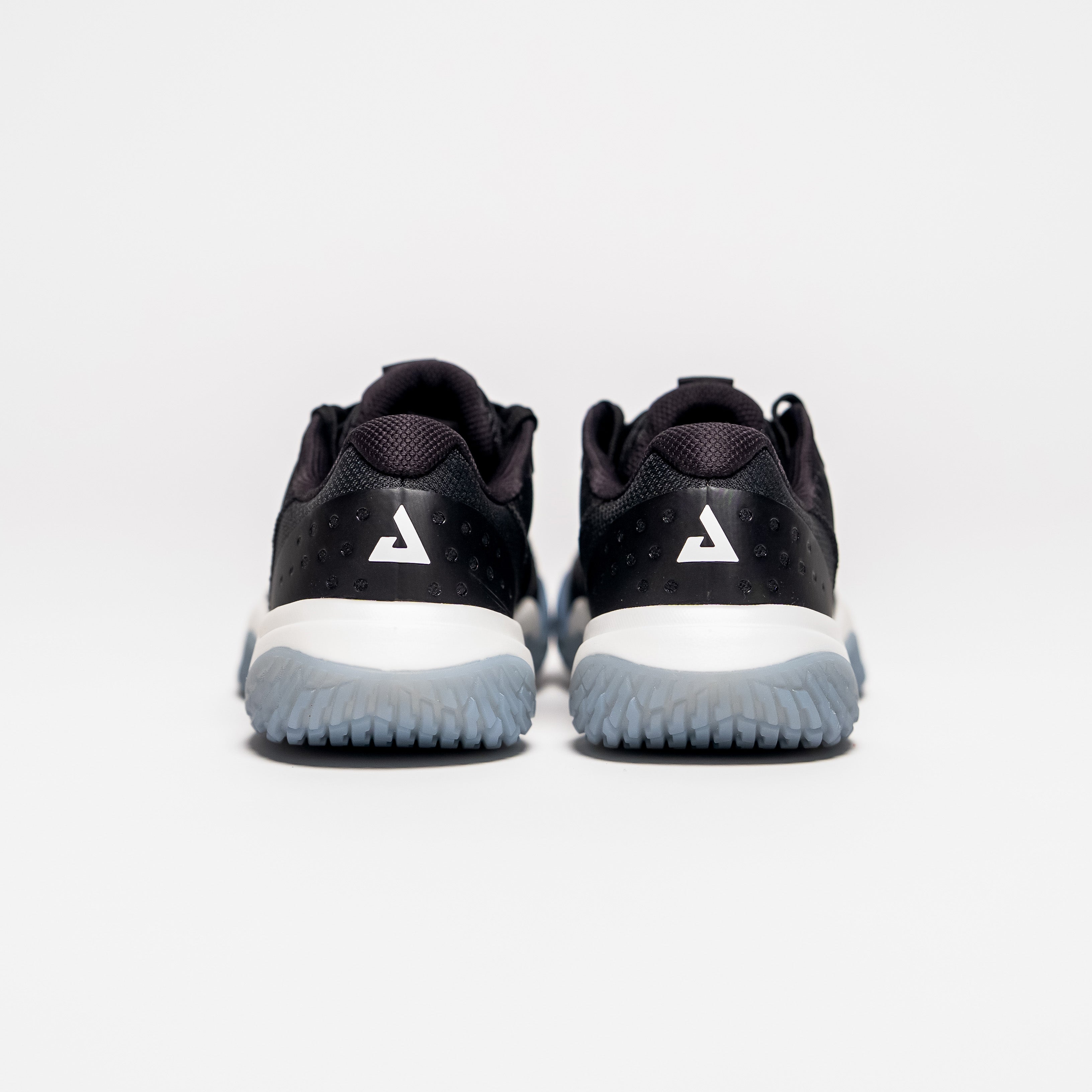 White background, product image showing the JOOLA Trinity logo on the back of a pair of black JOOLA R4LLy pickleball shoes.