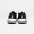 White background, product image showing the JOOLA Trinity logo on the back of a pair of black JOOLA R4LLy pickleball shoes.