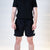White background, man wearing a pair of JOOLA x Hugo Calderano table tennis shorts, black.