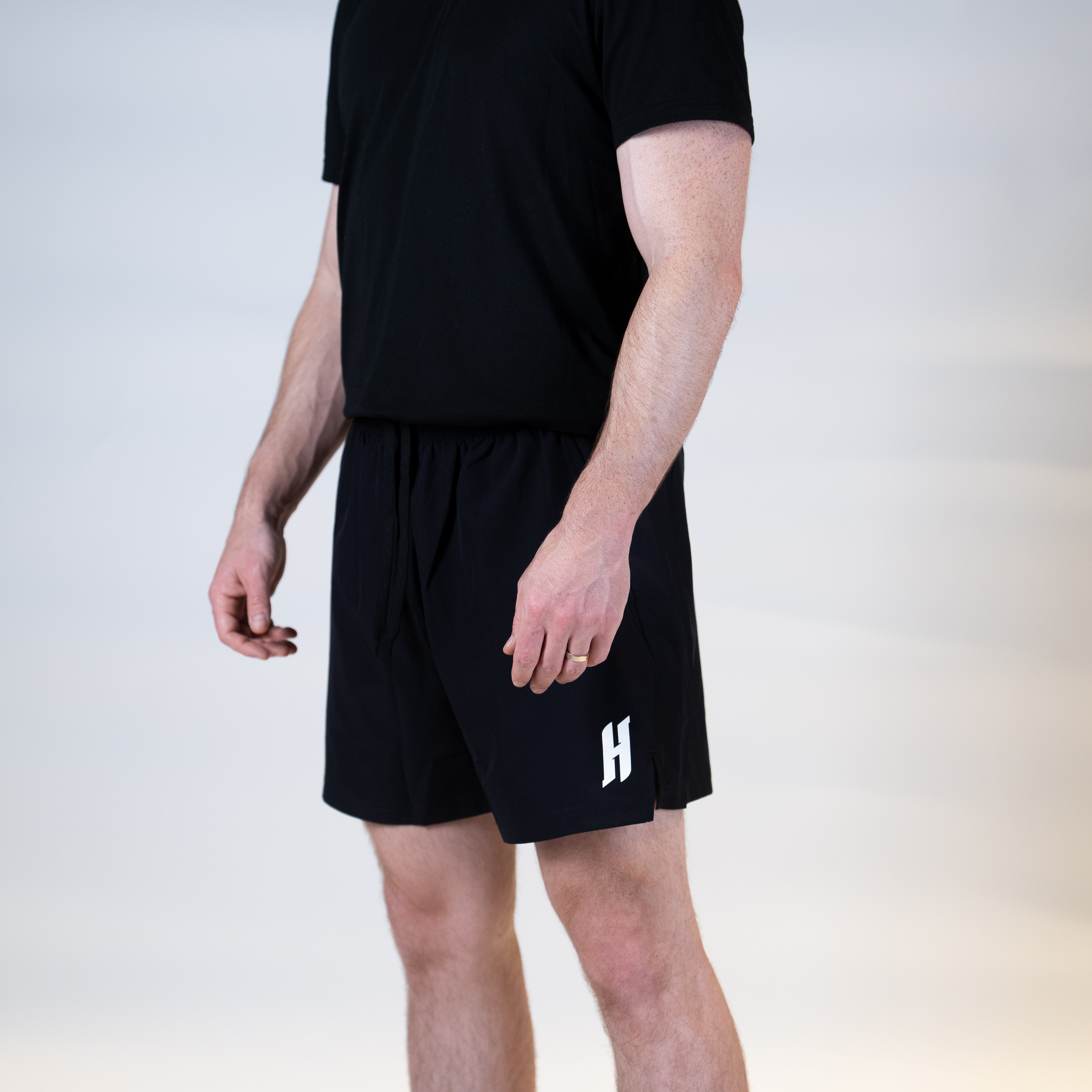 White background, product image showing a male model wearing a pair of JOOLA x Hugo Calderano shorts, image shoes the stylized H on the shorts.
