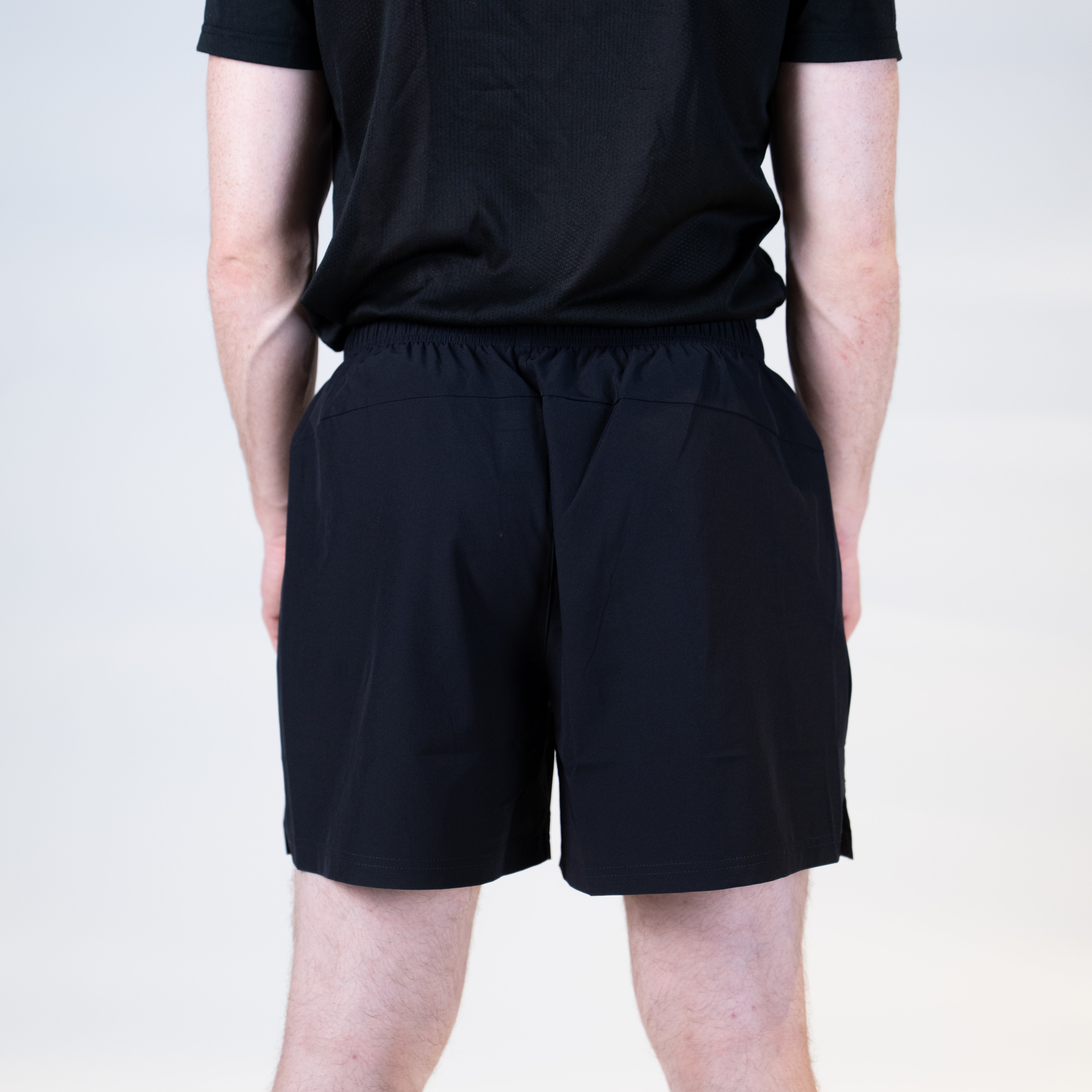White background, product image showing the rear view of a male model wearing a pair of Hugo Calderano table tennis shorts.
