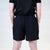 White background, product image showing the rear view of a male model wearing a pair of Hugo Calderano table tennis shorts.
