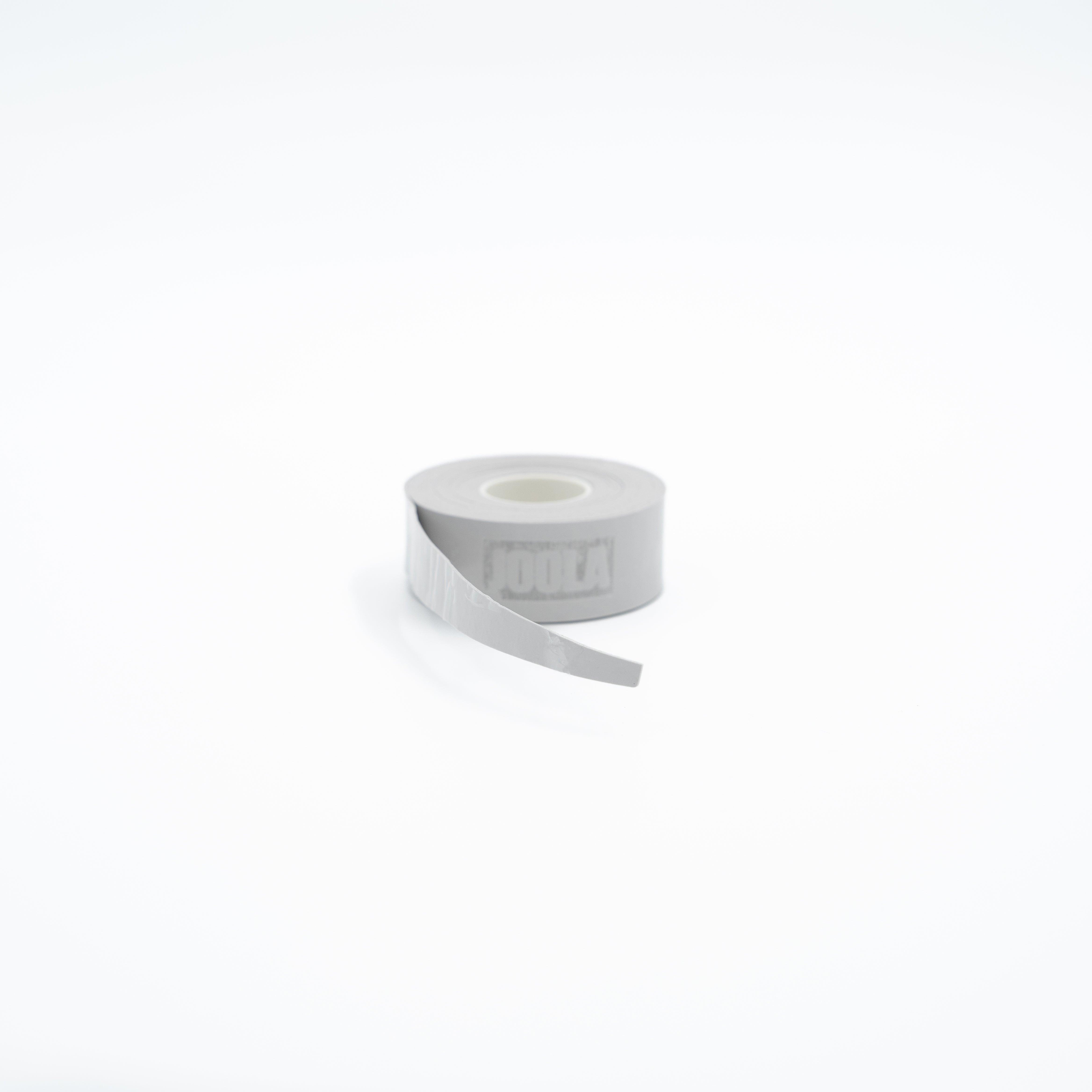 A roll of light gray athletic tape with a partially unrolled strip, featuring the brand name JOOLA embossed on the side, set against a seamless white background.