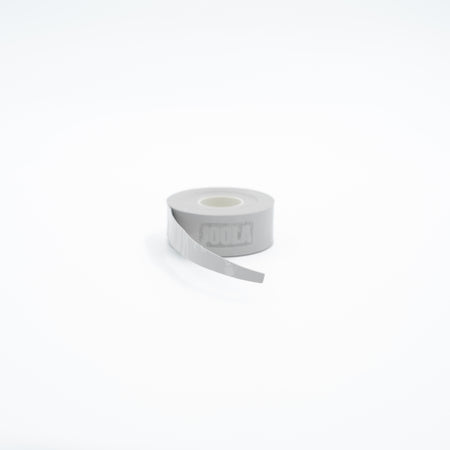 A roll of light gray athletic tape with a partially unrolled strip, featuring the brand name JOOLA embossed on the side, set against a seamless white background.