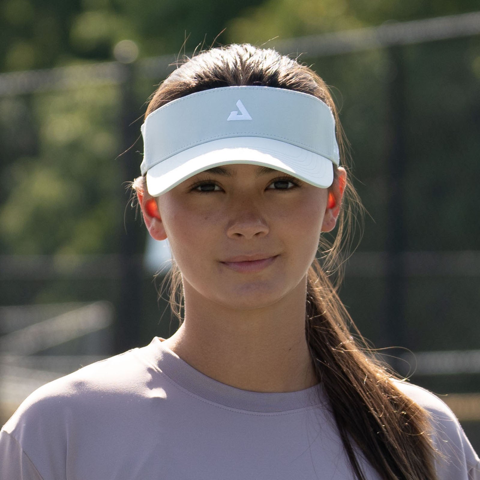 Image of a female model outside wearing a JOOLA Essential Visor, Gravity Gray.