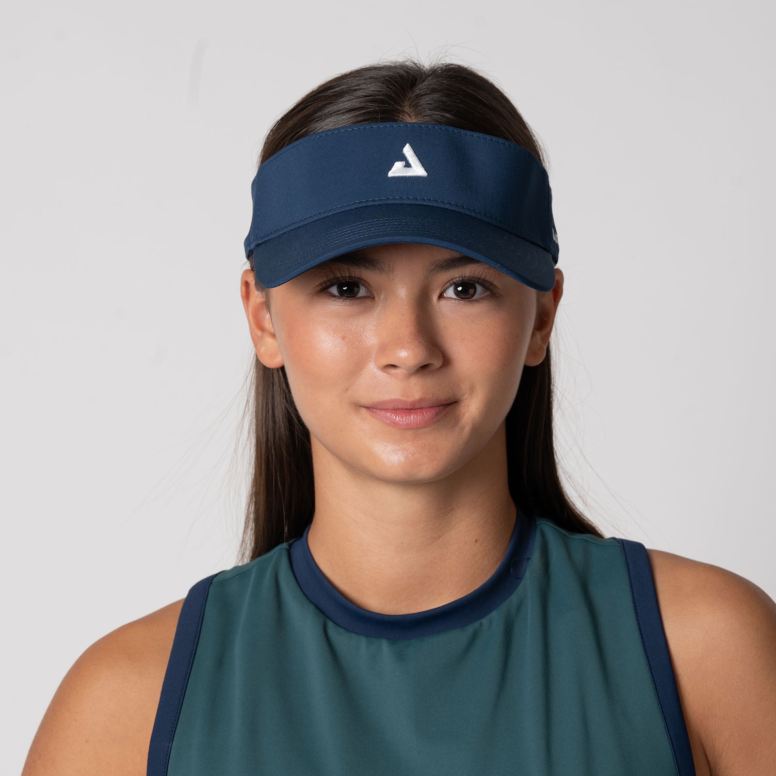 Headshot style image of a female model wearing a JOOLA Essential Visor, Navy.