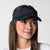 White background, image of a female model wearing a JOOLA Essential Visor, black.