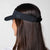 Image showing the back of a female models head who is wearing a JOOLA Essential Visor, black.