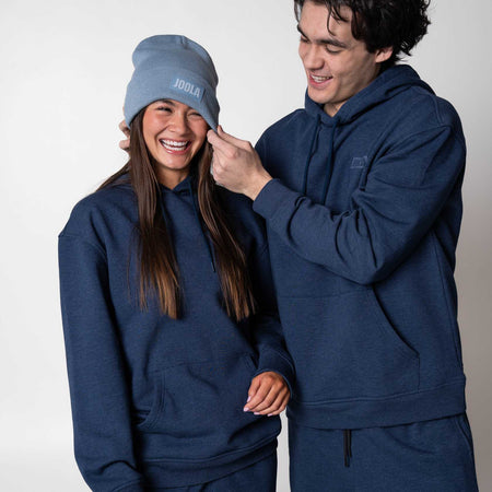 Two models wearing matching JOOLA Fleece Hoodies, Navy. Female model is wearing a JOOLA beanie.