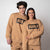 Gray background, two models wearing full JOOLA fleece gear, crew and pants, latte colored.