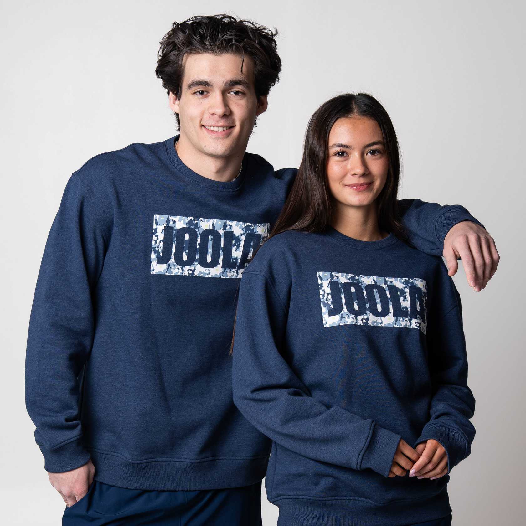 Gray background, two models wearing matching JOOLA Fleece Crew, Navy.