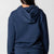 Gray background, image showing the back of a female model who is wearing a JOOLA Fleece Hoodie, Navy.