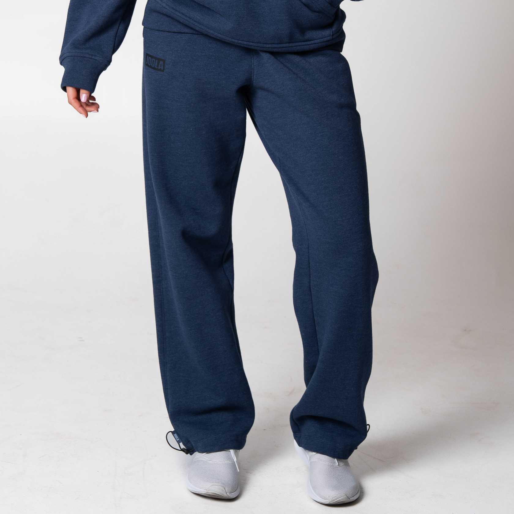 Gray backgound, image of a person wearing a pair on JOOLA Fleece pants, navy.