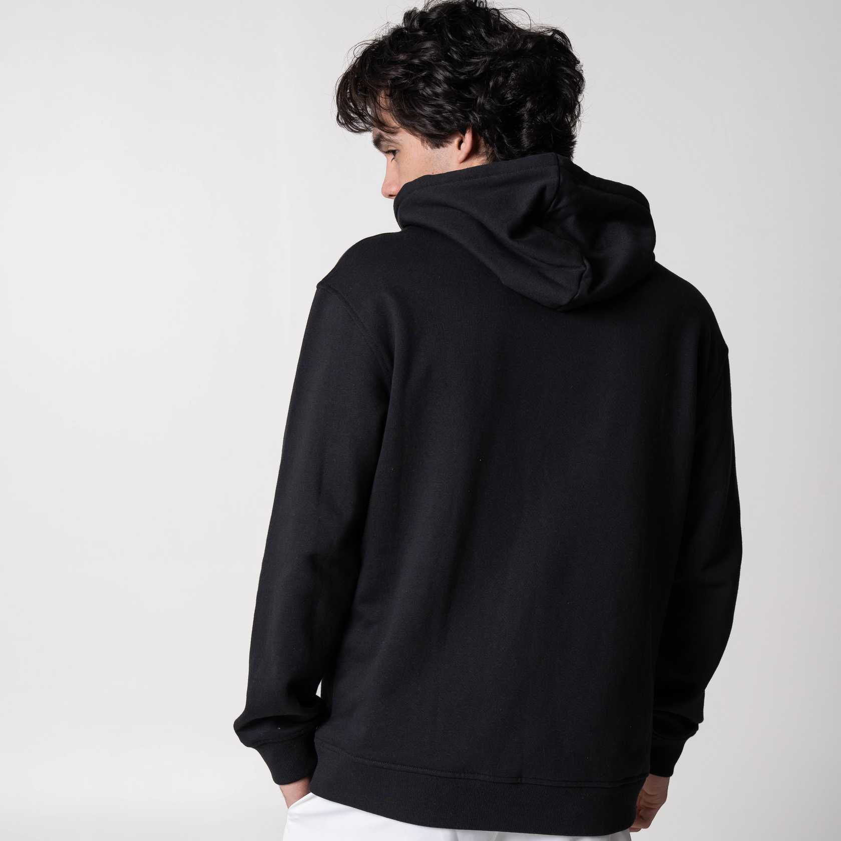 Gray background, image of showing the back of a male model wearing a black JOOLA Graphic Hoodie.