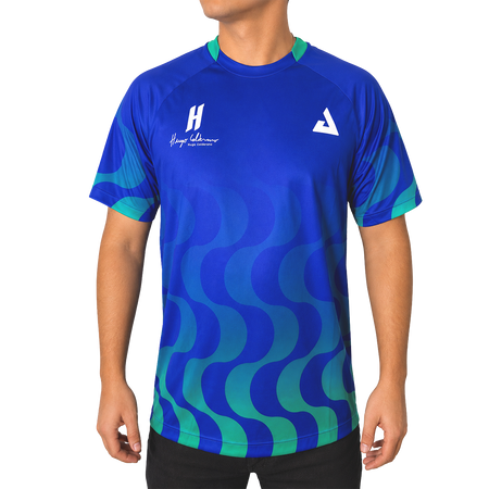 White background, product image showing a male model wearing an Azul  colored Hugo Calderano Copacabana Raglan Short Sleeve.