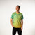 White background, image of Hugo Calderano wearing a Hugo Calderano Gradient Monogram Raglan Short Sleeve shirt. Jungle Green colorway.