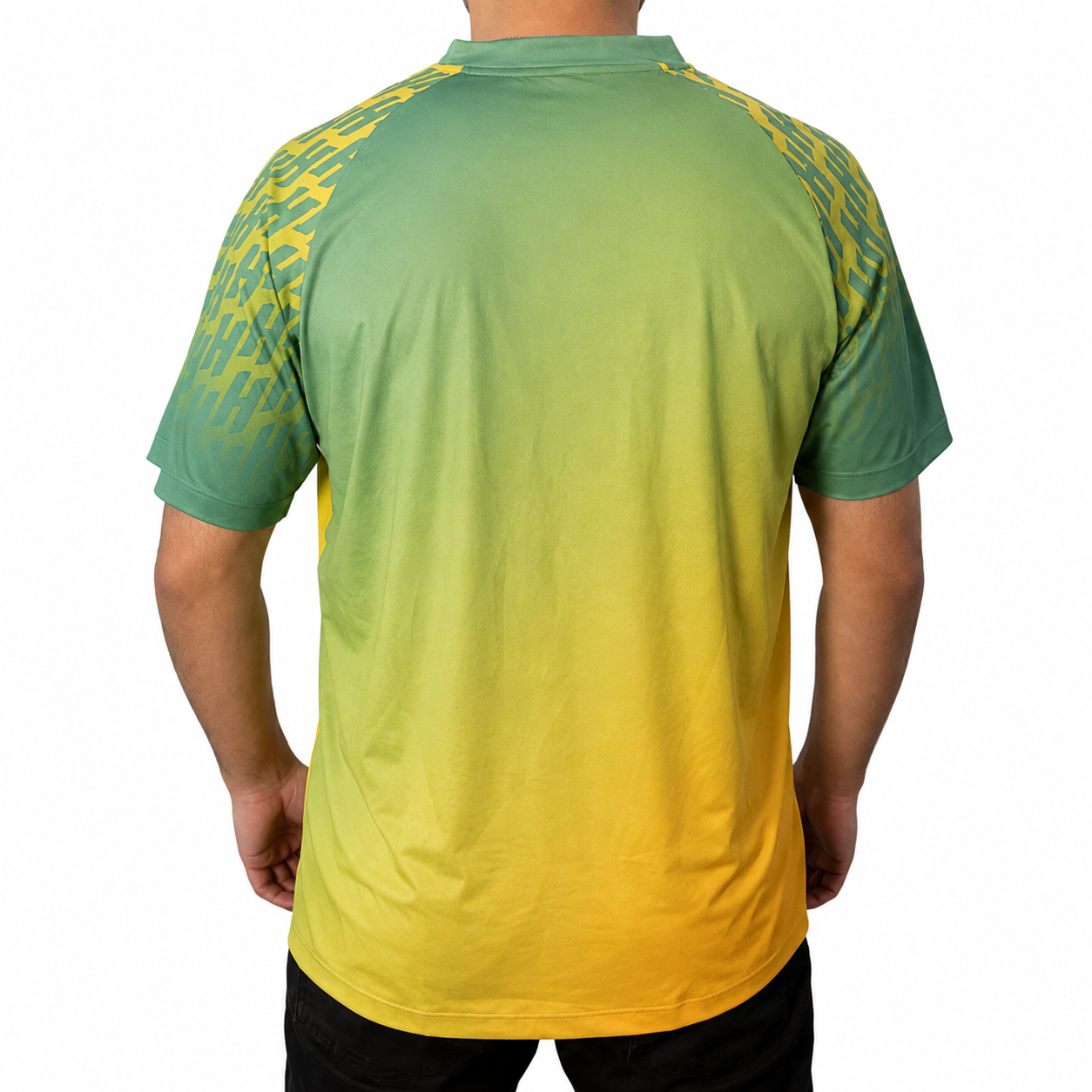 White background, image of Hugo Calderano wearing a Hugo Calderano Gradient Monogram Raglan Short Sleeve shirt. Jungle Green colorway.