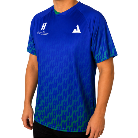 White background, image of a male model wearing a JOOLA Hugo Calderano Crossover Raglan Short Sleeve shirt, Azul colorway.