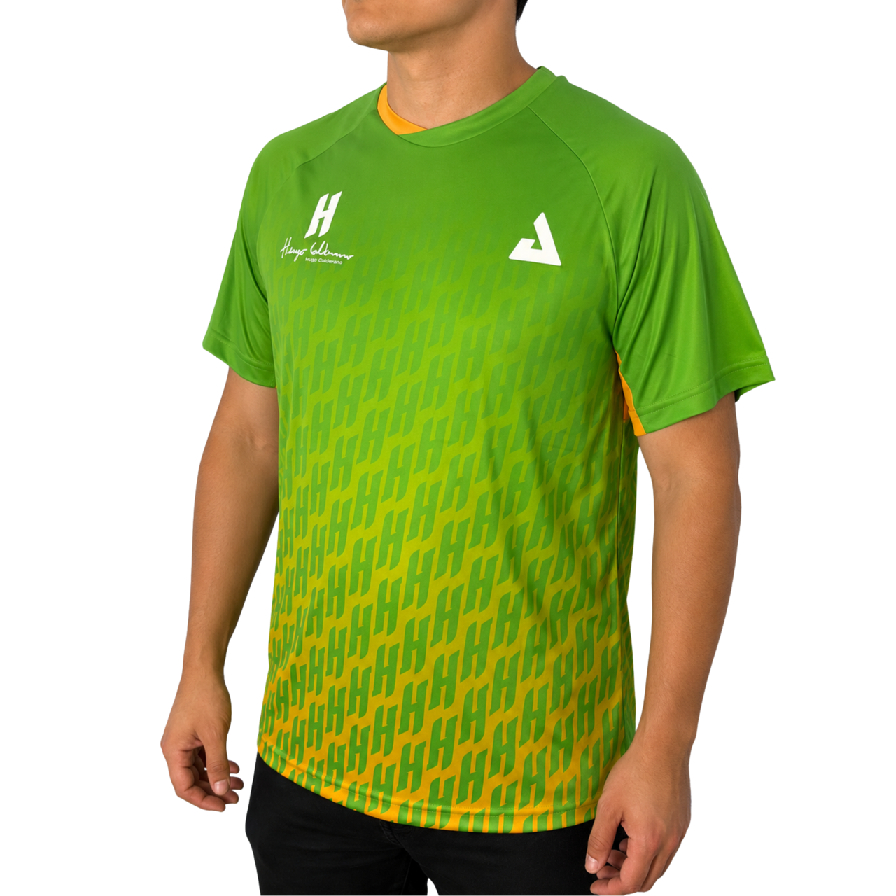 White background, male model wearing a jungle green colorway Hugo Calderano Monogram Crossover Raglan sleeve short sleeve shirt.