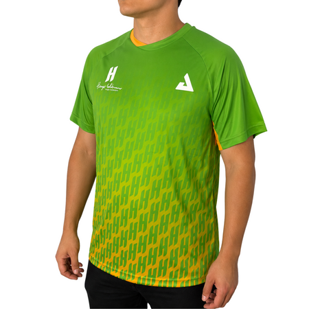 White background, male model wearing a jungle green colorway Hugo Calderano Monogram Crossover Raglan sleeve short sleeve shirt.