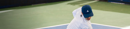 Horizontal image of the JOOLA Essential hat on top of Ben Johns' head. Hat is blue with white JOOLA trinity logo.