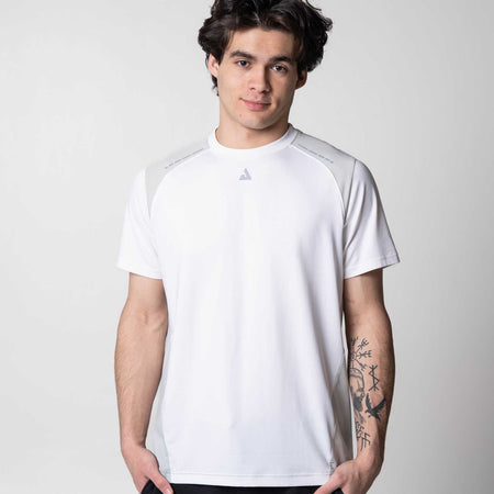 Gray background, image of a model wearing a JOOLA Hybrid short sleeve shirt, white.