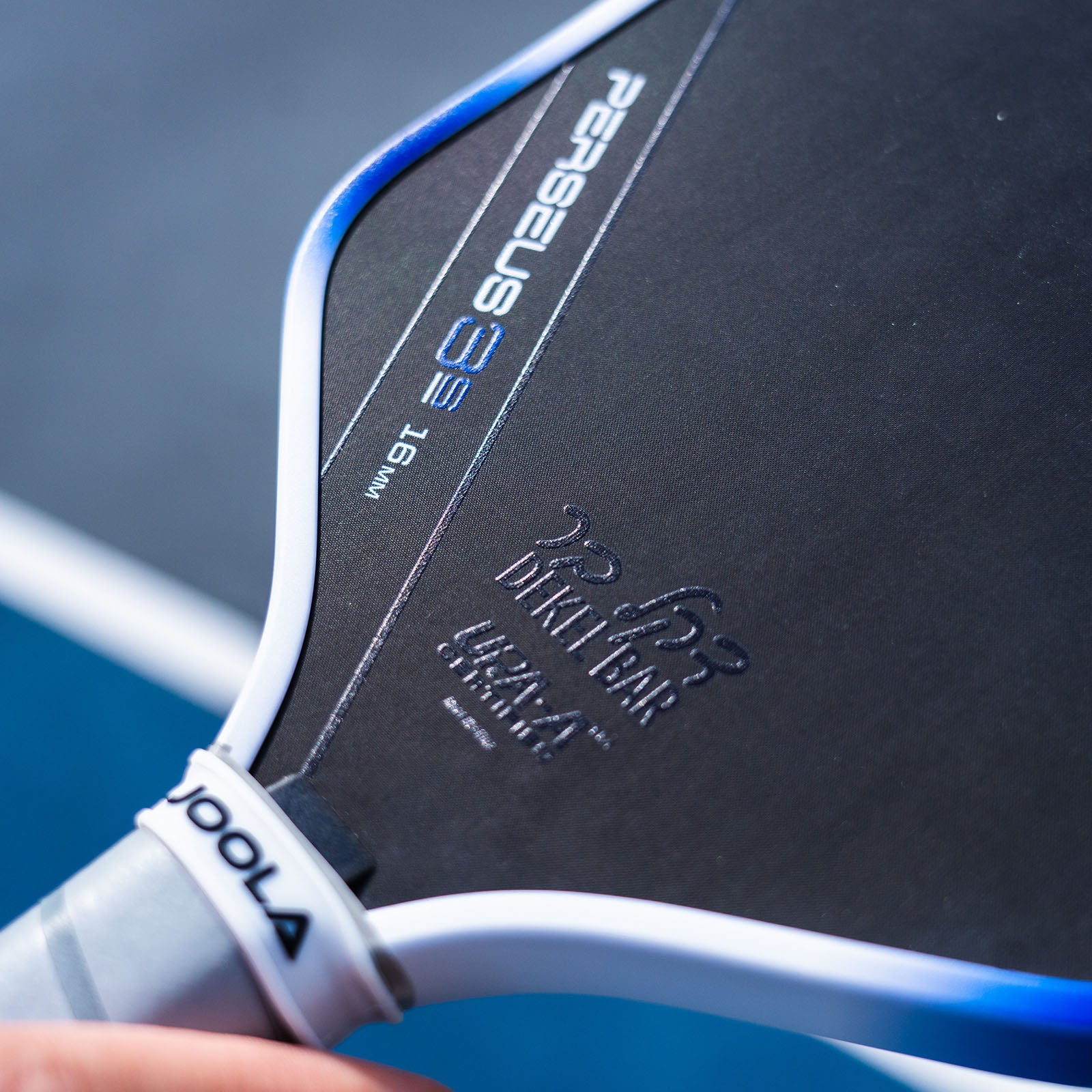 Close up image of the Dekel Bar signature in Hebrew lettering on the JOOLA Dekel Bar Perseus pickleball paddle.