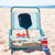 Blue folding chair with a JOOLA Kosmos Rally Rocket pickleball paddle, JOOLA pops coozie on a beach. 