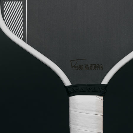 Close up image of the Tyson McGuffin signature on the black paddle face of the JOOLA Tyson McGuffin Pro IV Pickleball Paddle.