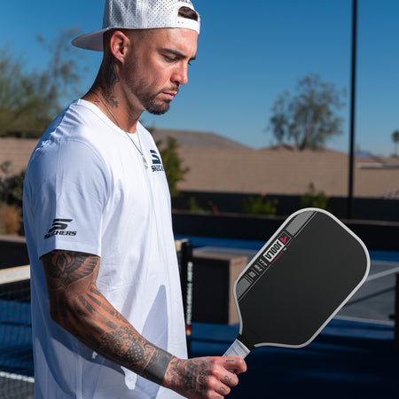 Close up image of Tyson McGuffin holding a JOOLA Tyson McGuffin Magnus Pro IV Pickleball paddle in his right hand.