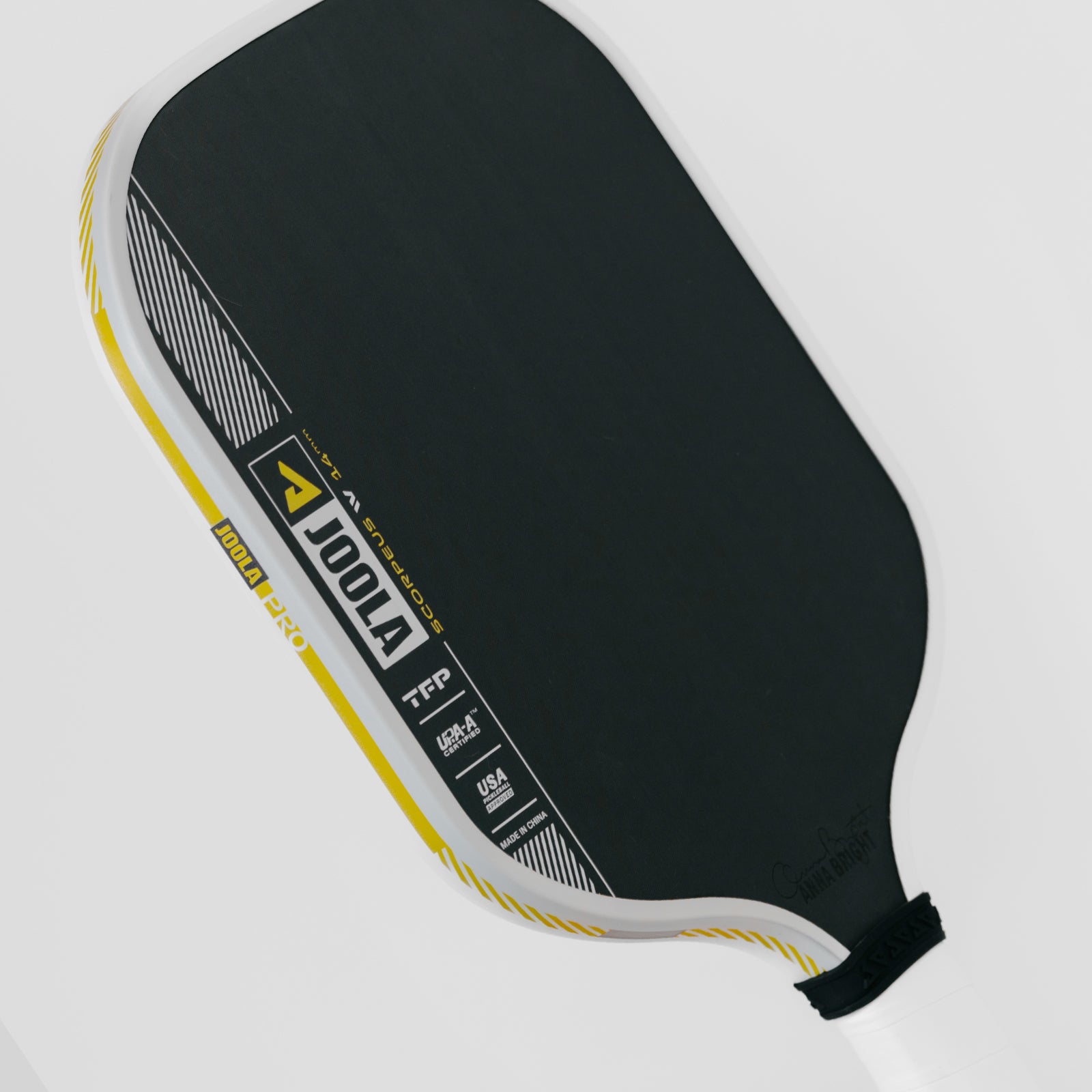 White background, close up image of the yellow, white and black edge guard on the JOOLA Anna Bright Scorpeus Pro IV Pickleball Paddle. 14mm.