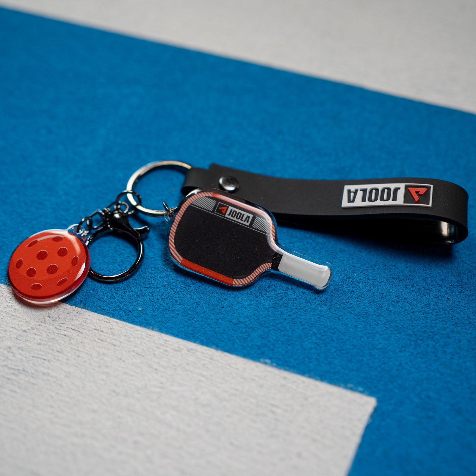 Close up of the Agassi Pro keychain on a JOOLA pickleball indoor court.