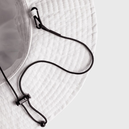 Close-up of a white brim with a black lanyard and 'JOOLA' branding on a light gray background.