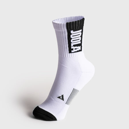 A single white crew sock with black accents, featuring a black cuff panel with the word 'JOOLA' in white and a black toe cap, shown on a light gray background.
