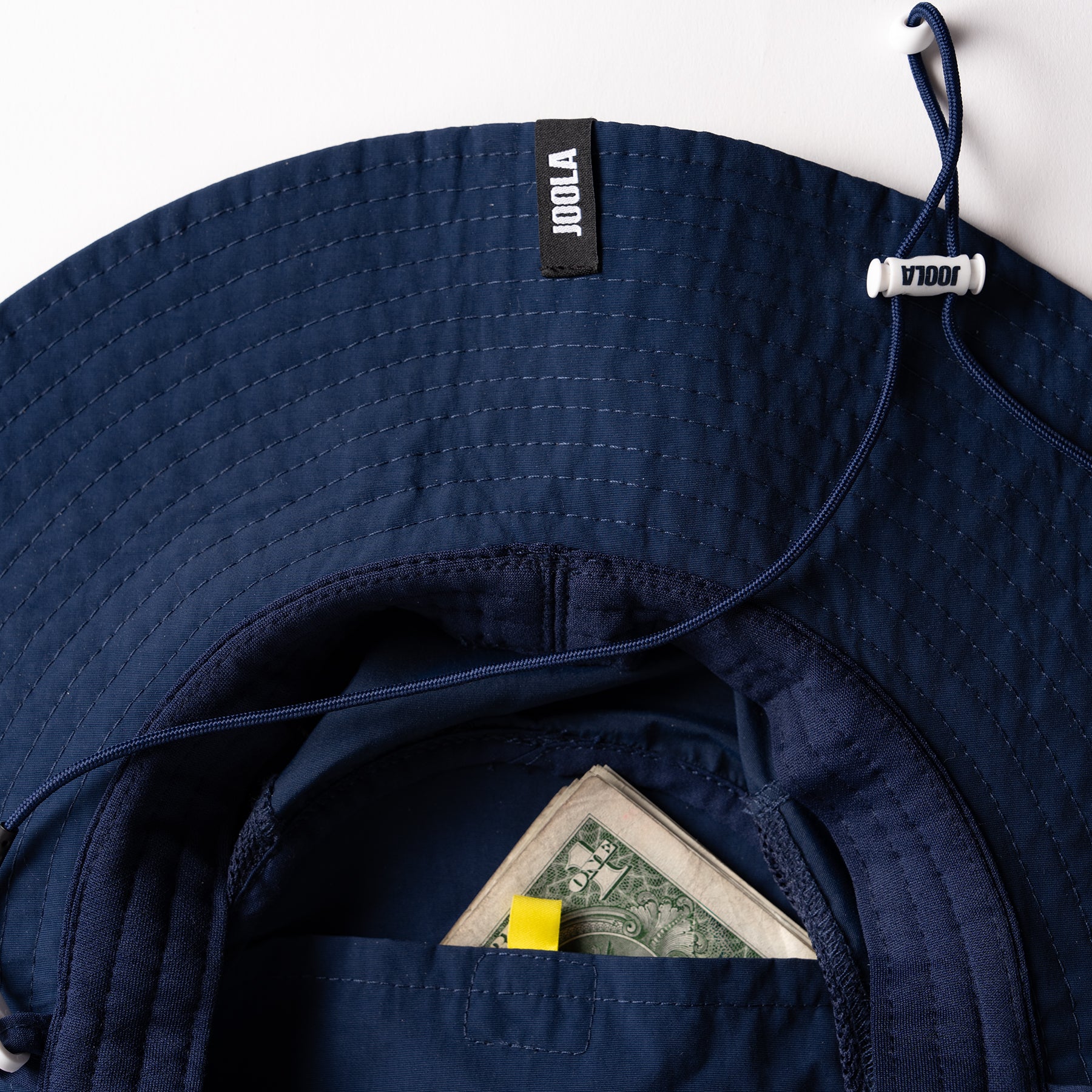 Image showing a secret pocket with money inside the JOOLA Wide Brim hat, navy blue.