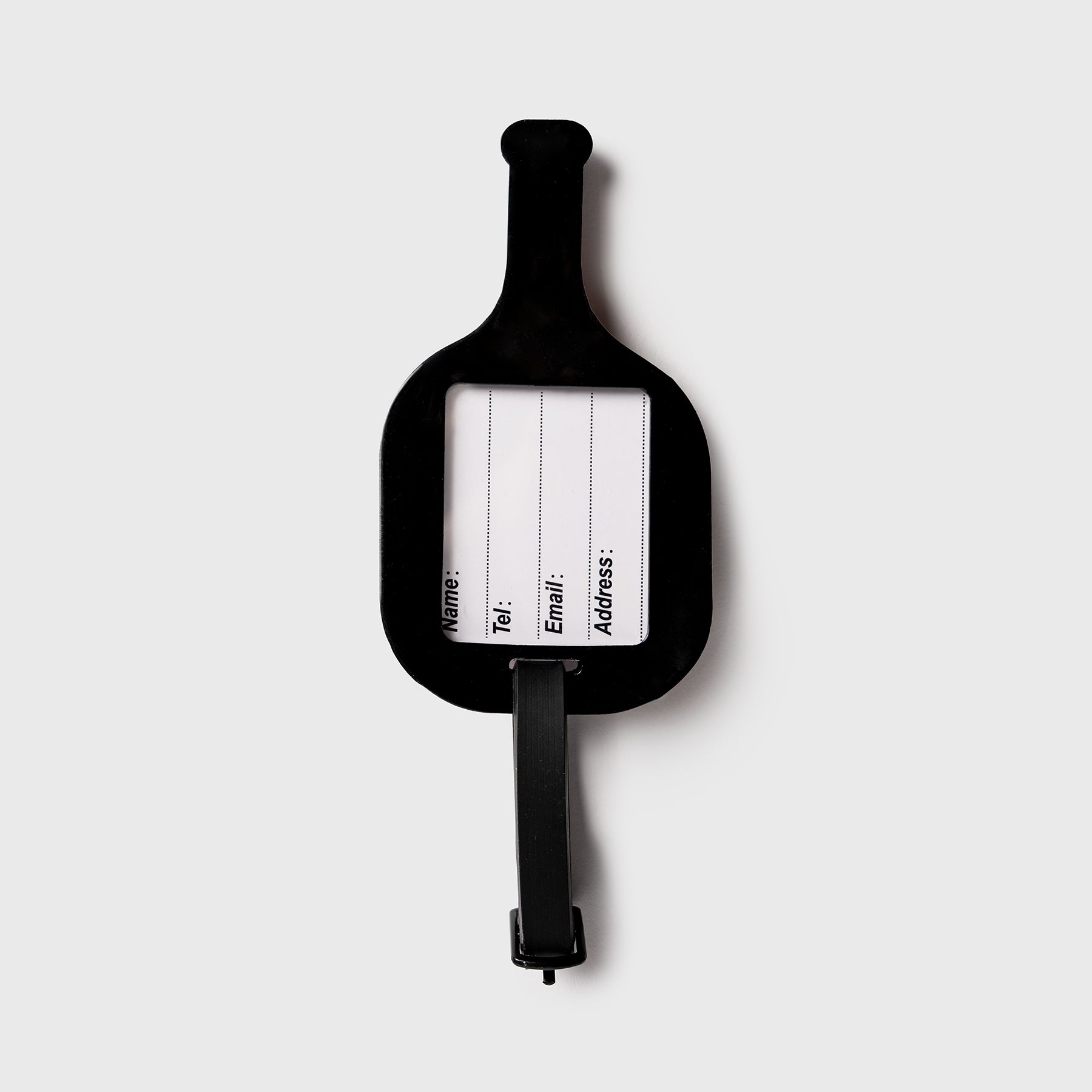 Black paddle-shaped luggage tag with a white label on a light gray background