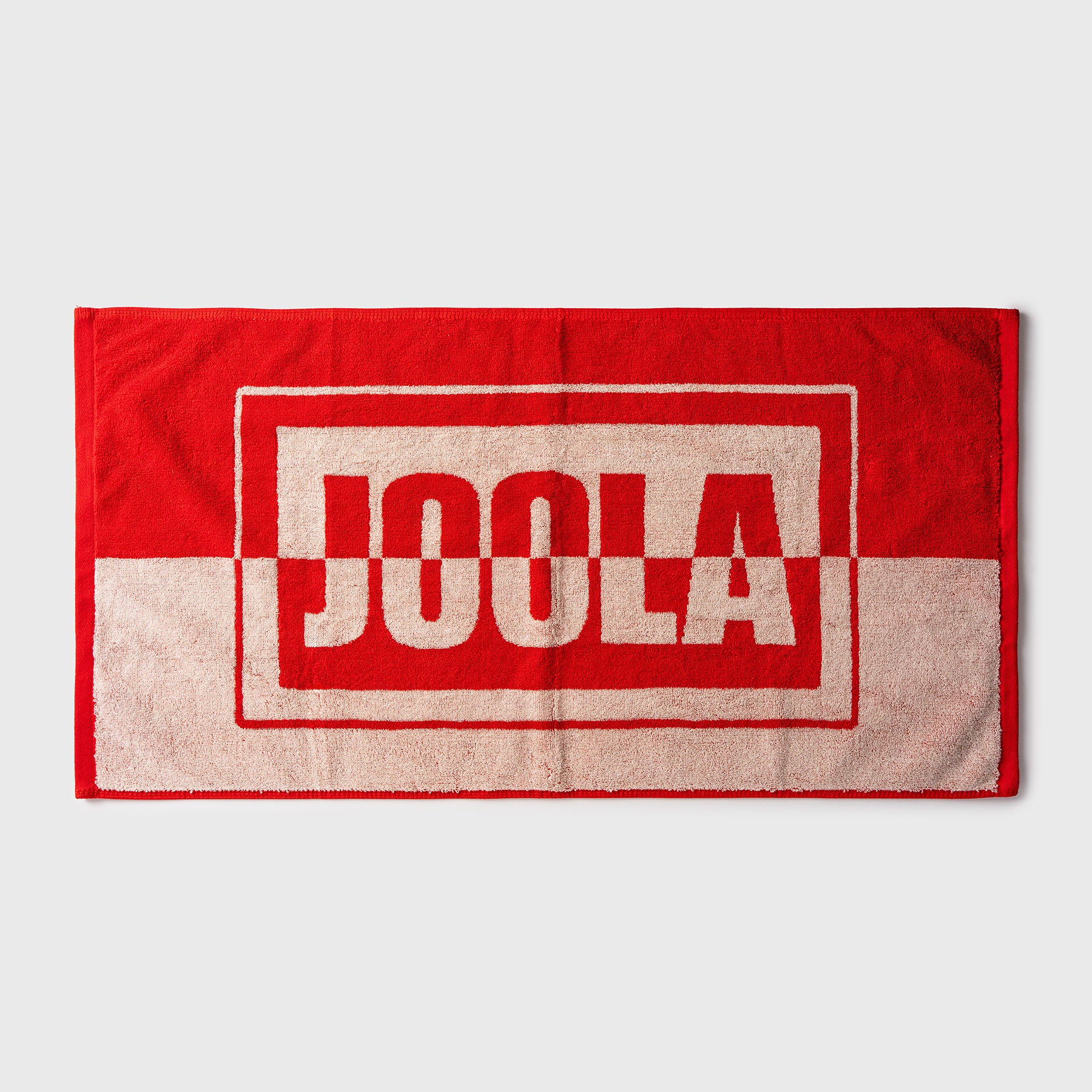 White background, red and beige JOOLA wordmark towel.