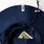 Close-up of a navy blue JOOLA sun hat with the brim curved downward, showing a white JOOLA brand tag on the inside and a coin pocket holding a dollar bill.