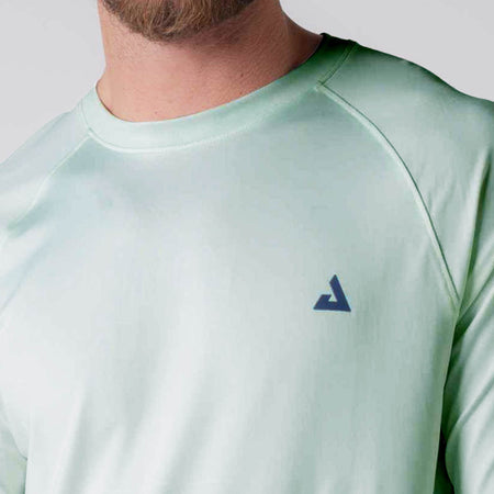 Close up image of the JOOLA logo over the left chest on a JOOLA Men's Court Long Sleeve, Hushed Mint.