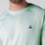 Close up image of the JOOLA logo over the left chest on a JOOLA Men's Court Long Sleeve, Hushed Mint.