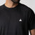 Close up image showing the JOOLA trinity logo on a JOOLA Men's Court Short Sleeve Shirt, black.