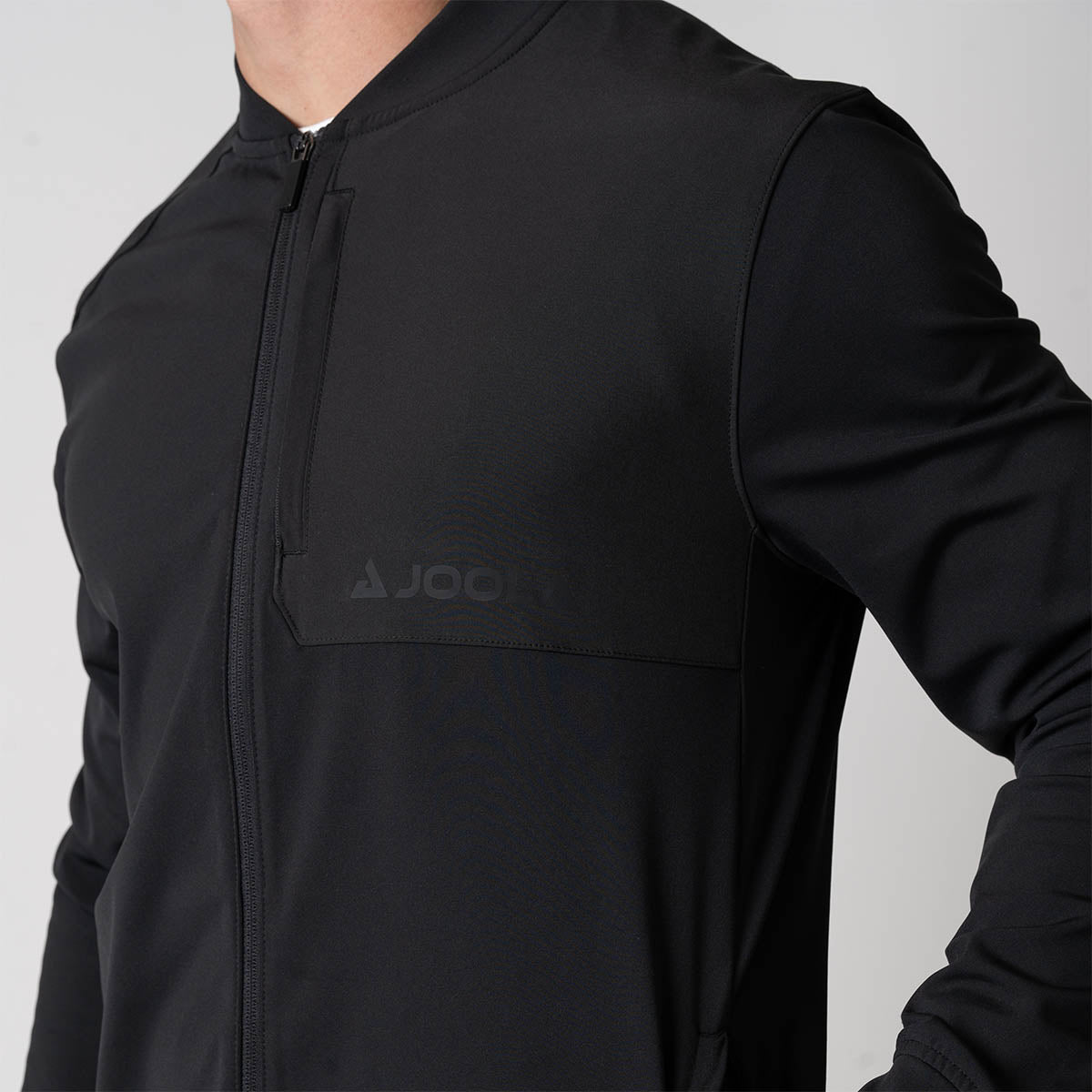 Close up image of the JOOLA Men's Warm Up Jacket, showing the JOOLA Logo, black.