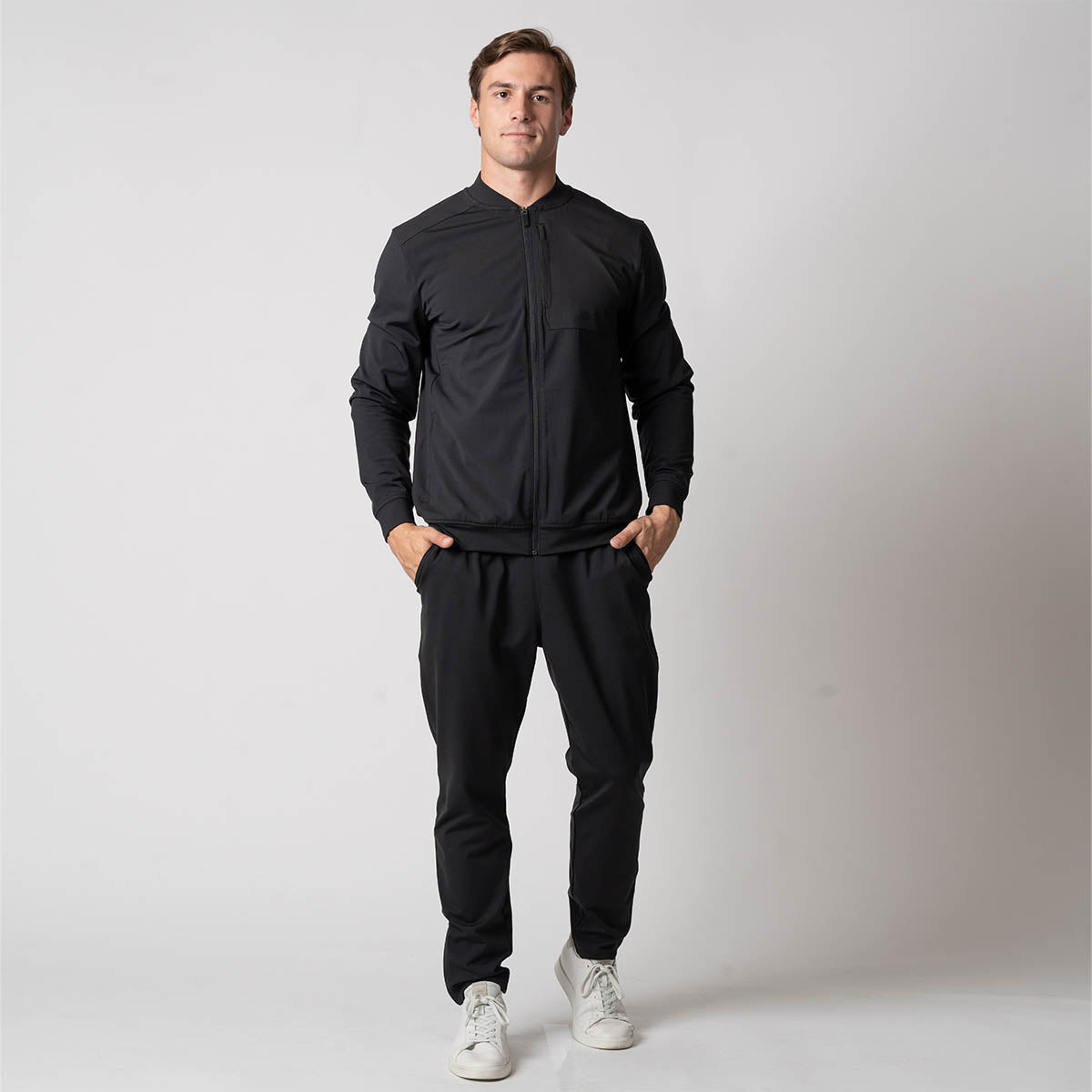 Image of a male model wearing the JOOLA Men's Warm Up Jacket and Men's Warm Up Pants, Black.