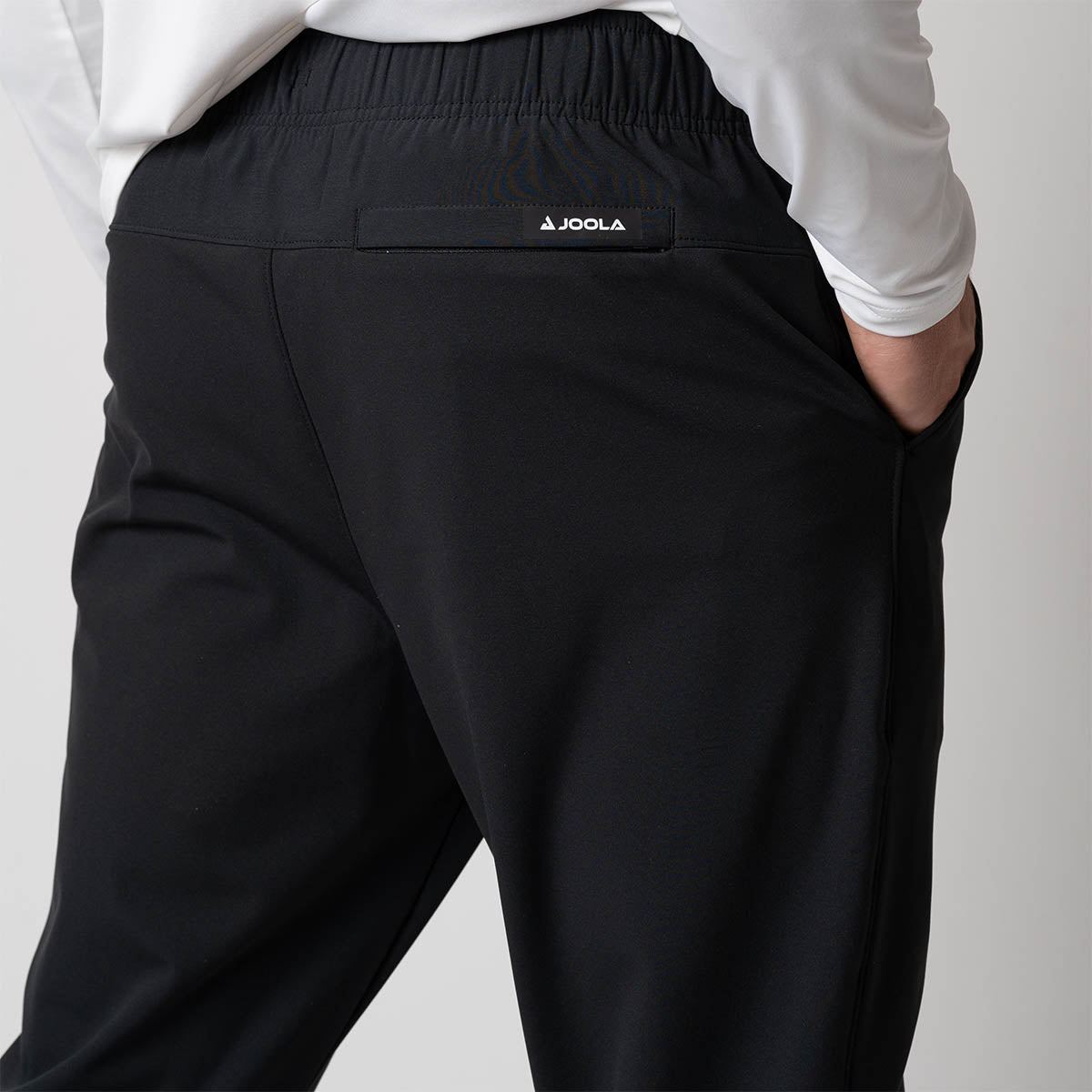 Close up image of the back of a pair of JOOLA Men's Warm Up pants, black.